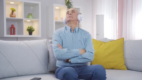 Old-man-listening-to-music-with-headphones-is-unhappy-and-sad.